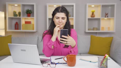 Woman-working-from-home-enjoys-mobile-apps-on-phone.